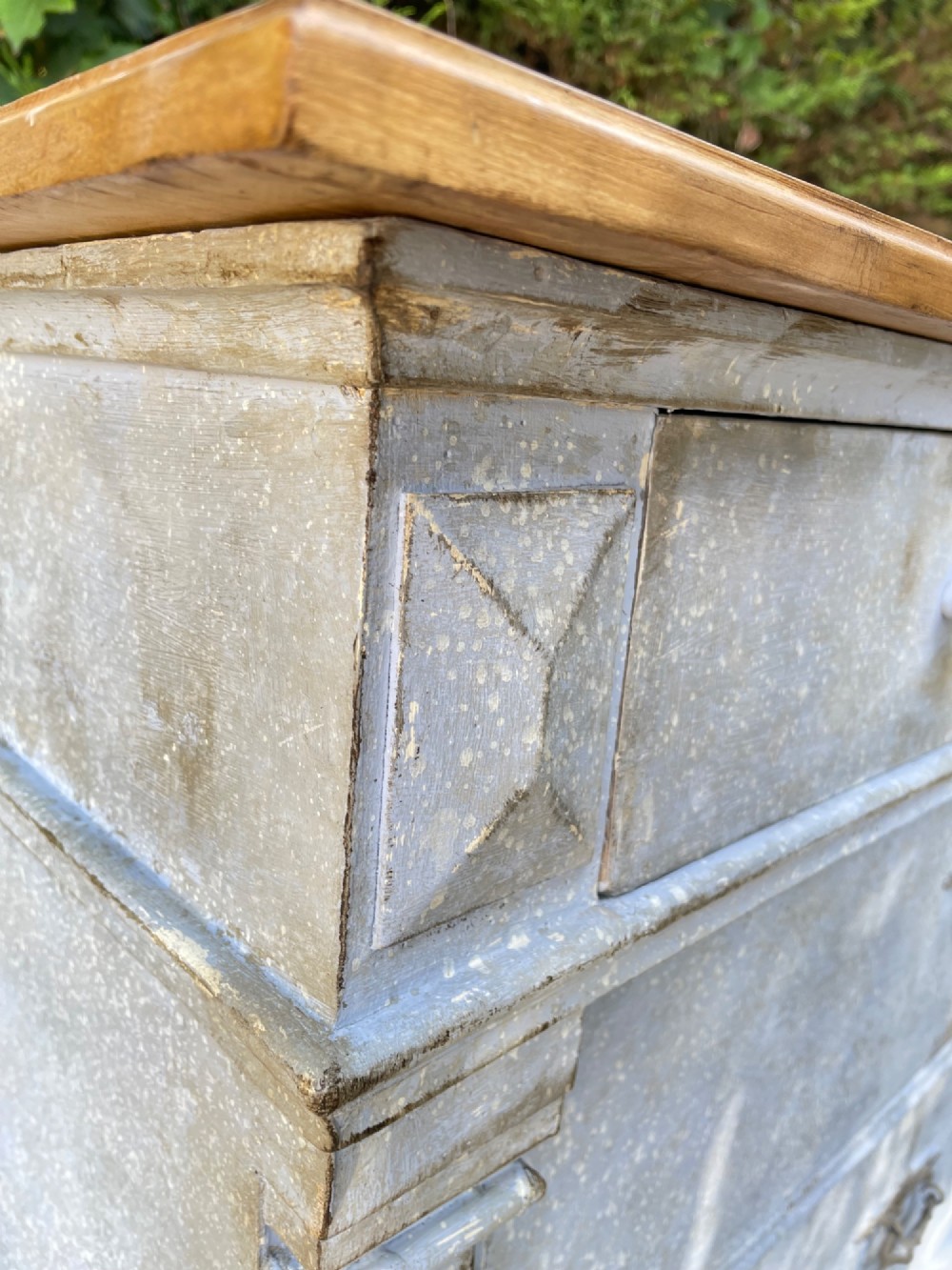 A French Gustavian style chest of drawers featuring a natural wood top, pale blue distressed paint finish, fluted corner pilasters, carved diamond-point details, and metal drop handles. View VIII