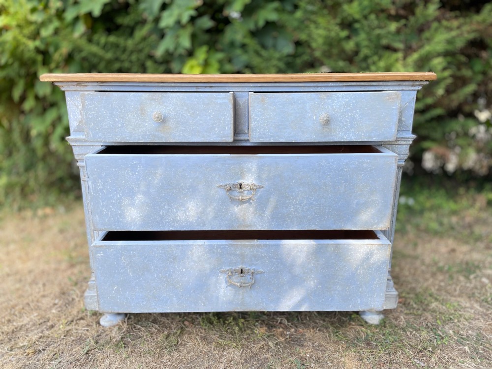 A French Gustavian style chest of drawers featuring a natural wood top, pale blue distressed paint finish, fluted corner pilasters, carved diamond-point details, and metal drop handles. View XI
