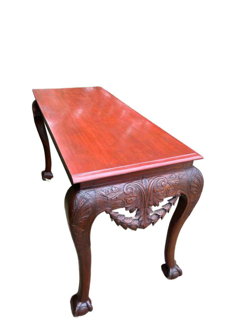 An Edwardian George II style mahogany serving table with an intricately carved apron featuring a central mask motif, raised on cabriole legs with claw and ball feet. View X