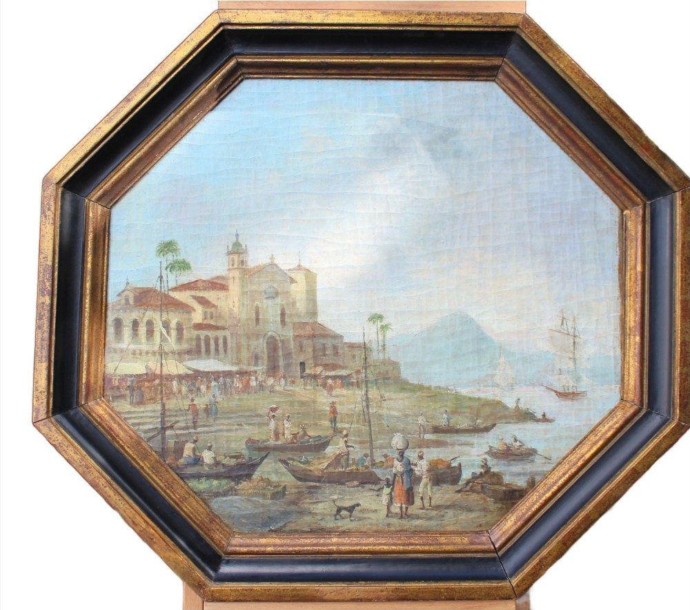 An early nineteenth-century octagonal oil painting depicting a harbour scene in Rio de Janeiro, housed in a moulded gilt and ebonised wooden frame.
