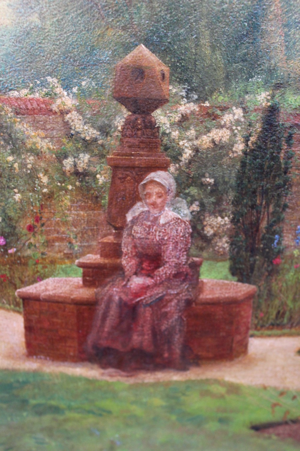 An antique oil painting depicting a woman seated in a walled garden surrounded by trees and a country house, set in an ornate gilded frame. View VI