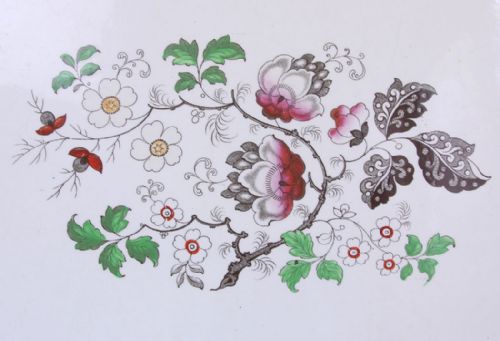 fig 1. A large 19th-century oval ironstone meat dish featuring a scalloped rim, geometric border, and hand-painted polychrome floral motifs on a white background.