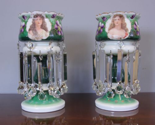 fig 1. A pair of Victorian green and white cased glass mantle lustres featuring hand-painted female portraits, purple floral decorations, and suspended clear crystal prisms.