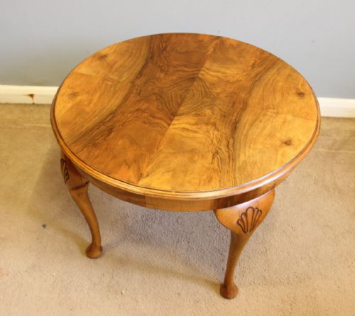 fig 1. A round figured walnut coffee table featuring four cabriole legs with carved shell knees and pad feet.