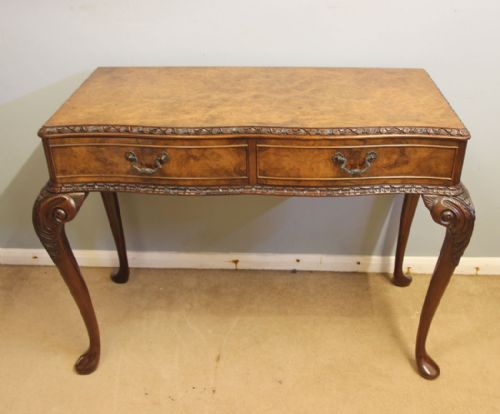 fig 1. An antique walnut side table featuring two veneered drawer fronts, carved edge moulding, brass handles, and slender cabriole legs with carved knees.