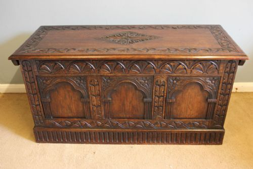 fig 1. A carved dark oak coffer featuring three carved arch panels on the front facade and a central diamond motif on the hinged lid.