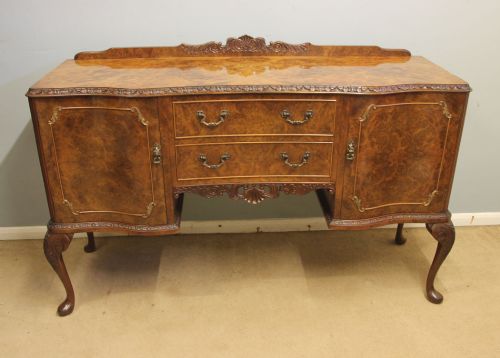fig 1. A burr walnut serpentine front sideboard featuring two central drawers flanked by side cupboards and raised on carved cabriole legs.