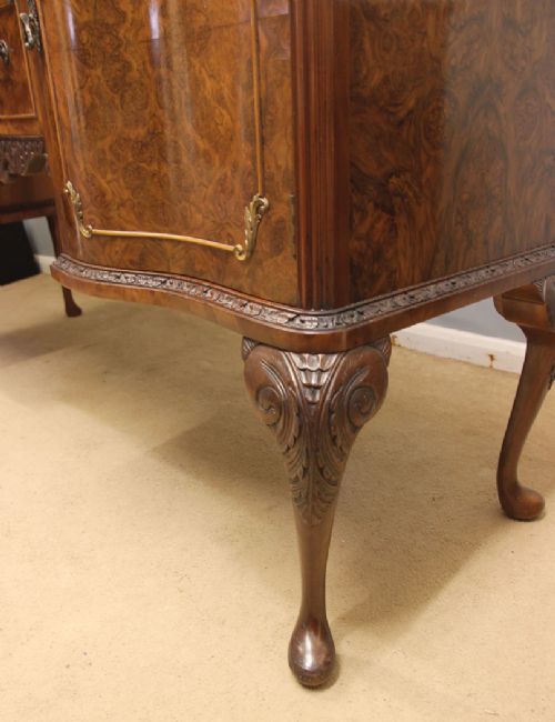 A burr walnut serpentine front sideboard featuring two central drawers flanked by side cupboards and raised on carved cabriole legs. View VIII