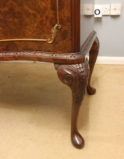 A burr walnut serpentine front sideboard featuring two central drawers flanked by side cupboards and raised on carved cabriole legs. View XIII