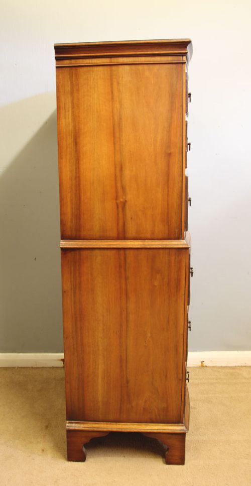 A tall burr walnut bow-front chest on chest featuring six stacked drawers, brass handles, and bracket feet. View IV