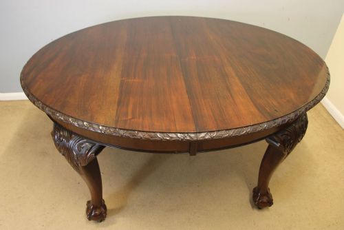 fig 1. An oval mahogany extending dining table with two insert leaves, carved border edging, cabriole legs featuring acanthus knee carvings, and ball-and-claw feet.