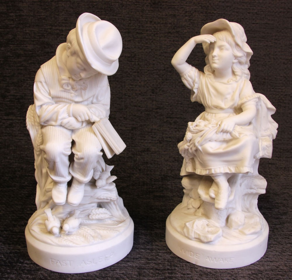 A pair of white Victorian Parian bisque porcelain figurines depicting a sleeping boy and an awake girl on circular bases inscribed Fast Asleep and Wide Awake.