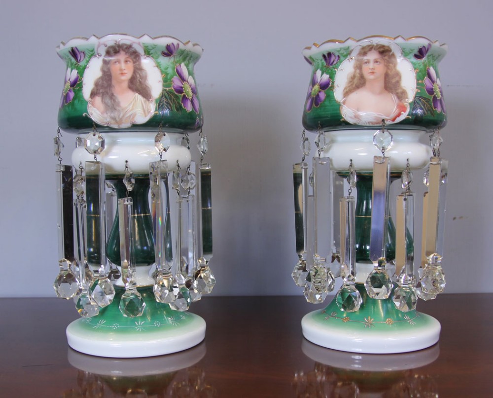 A pair of Victorian green and white cased glass mantle lustres featuring hand-painted female portraits, purple floral decorations, and suspended clear crystal prisms.