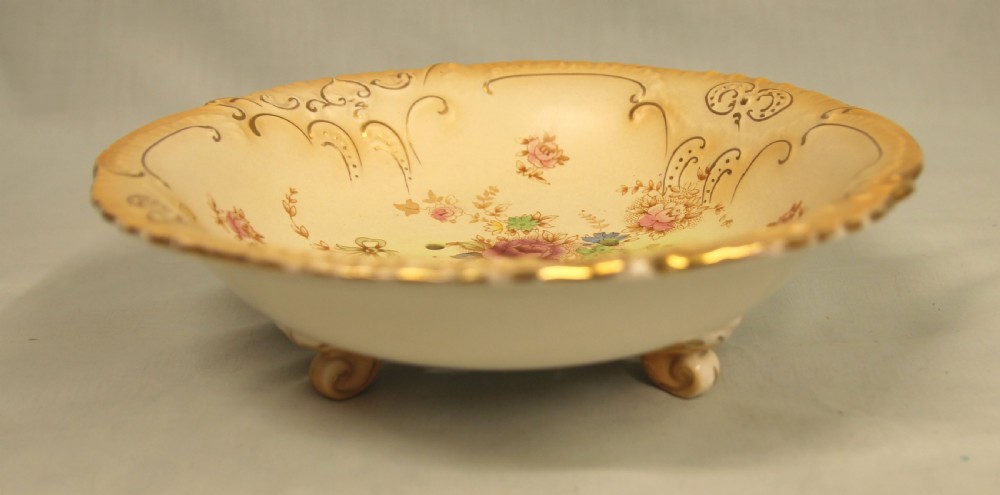 A Victorian Crown Devon blush ivory ceramic draining bowl with pierced holes and floral motifs, set on a matching gilded underplate. View VI