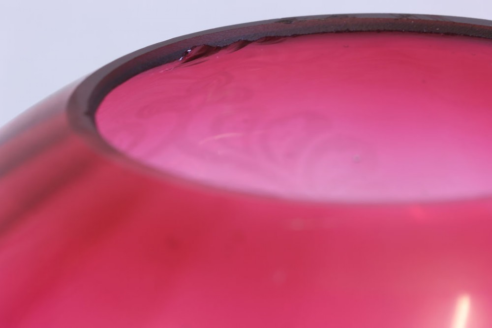 A dome-shaped Victorian cranberry glass oil lamp shade with acid-etched floral and foliate scrolling motifs fading from deep pink to clear glass. View VI