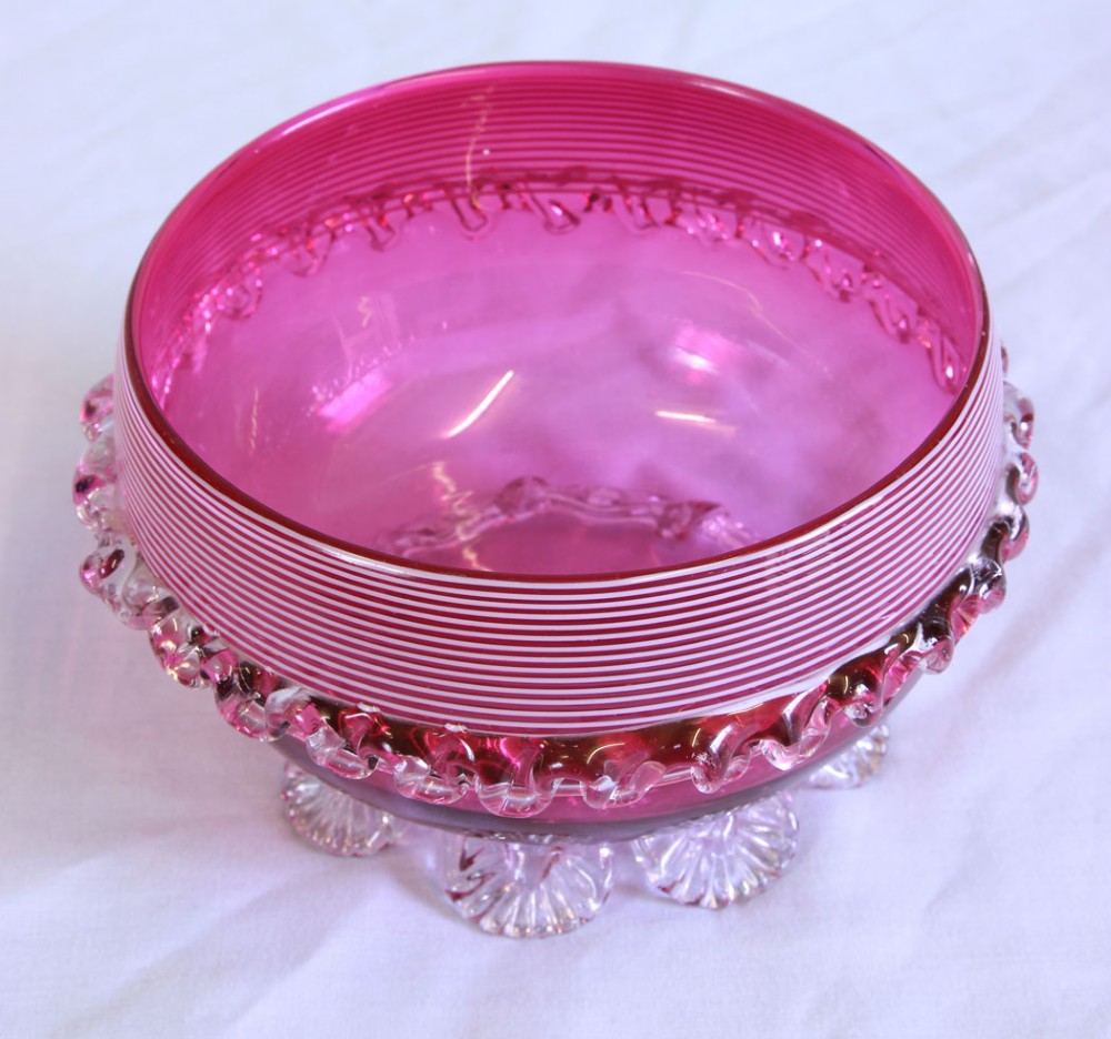 A Victorian cranberry pink glass bowl featuring fine horizontal white threading, an applied clear frilled band, and shell-shaped clear glass feet. View III