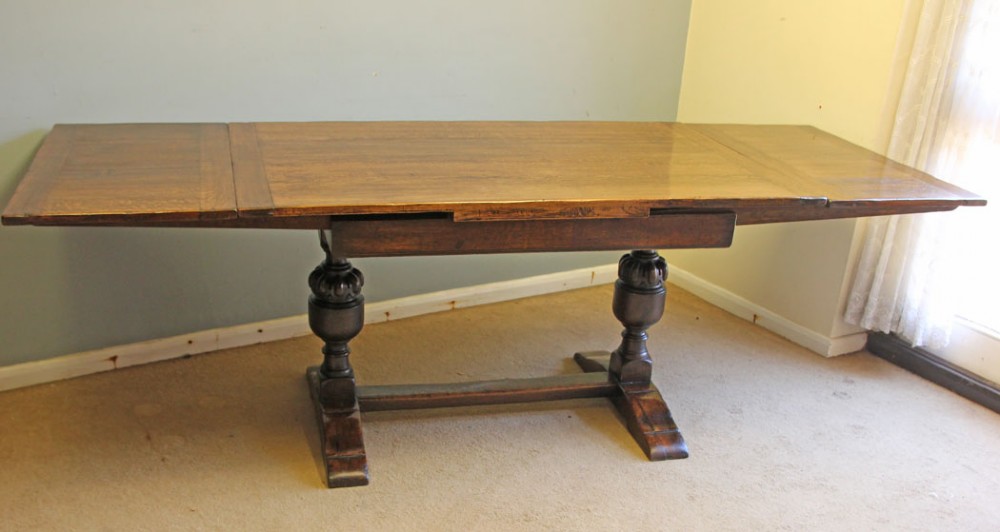 A solid oak extending refectory dining table featuring carved bulbous legs and an H-stretcher base. View IV