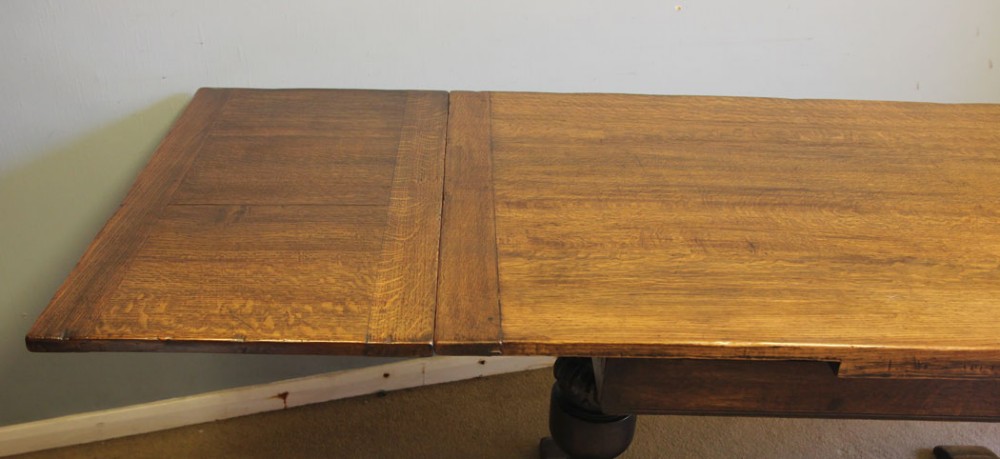 A solid oak extending refectory dining table featuring carved bulbous legs and an H-stretcher base. View VII