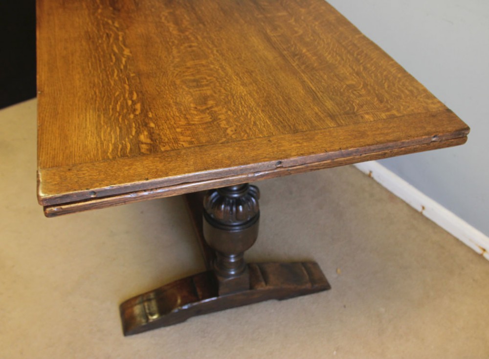 A solid oak extending refectory dining table featuring carved bulbous legs and an H-stretcher base. View X