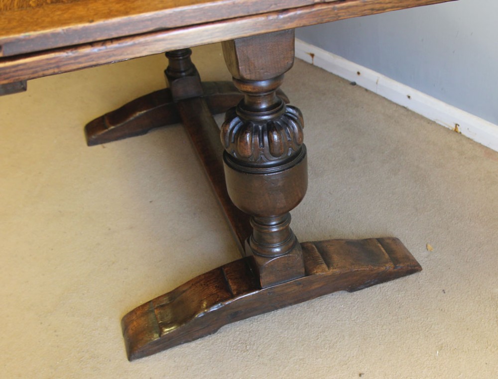 A solid oak extending refectory dining table featuring carved bulbous legs and an H-stretcher base. View XI