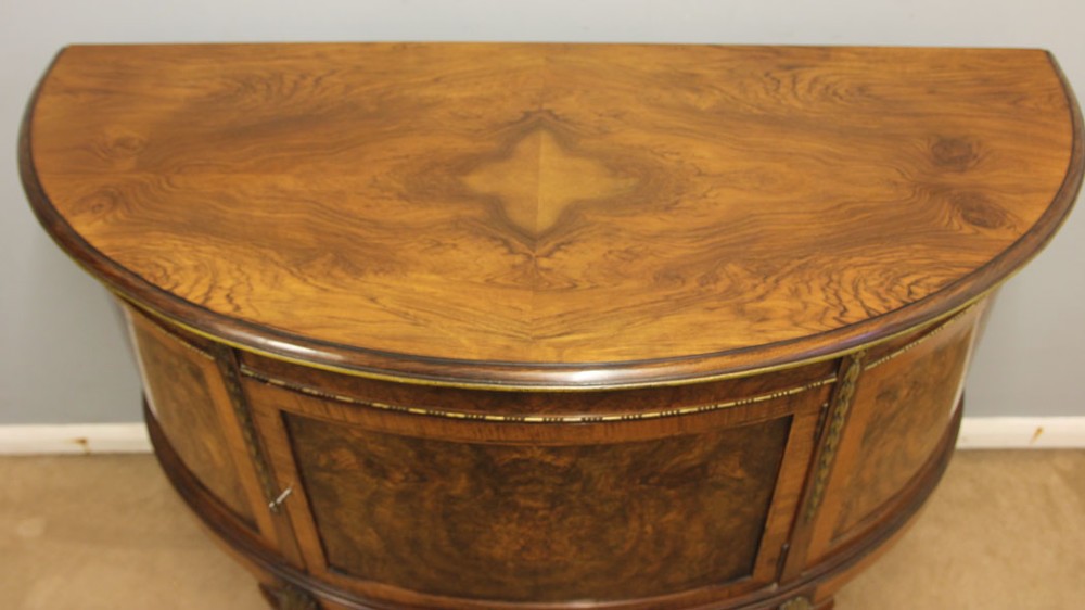 A semi-circular burr walnut side cabinet featuring cabriole legs with shell carvings and brass mounts. View XII