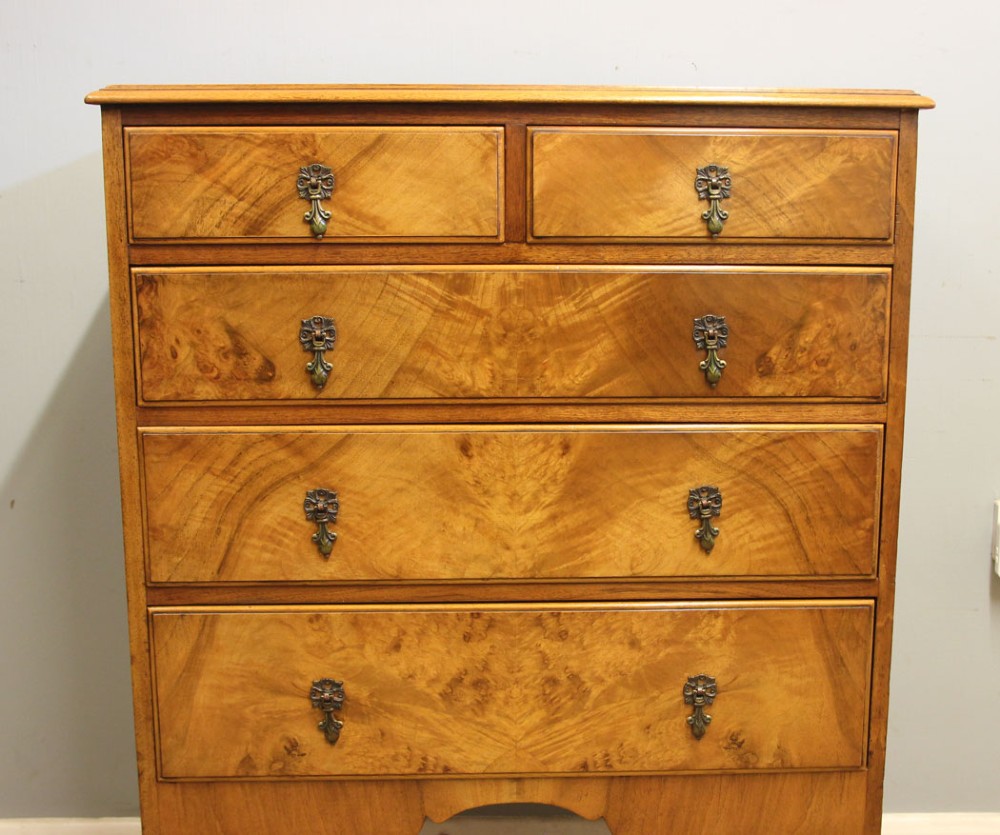 An antique figured walnut chest featuring two short drawers over three long drawers, resting on elevated cabriole legs with brass drop handles. View VII