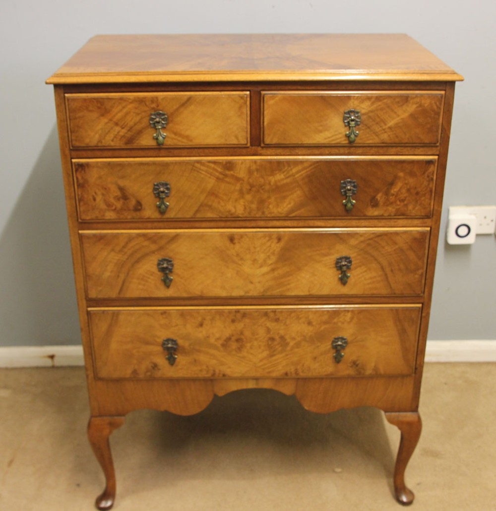 An antique figured walnut chest featuring two short drawers over three long drawers, resting on elevated cabriole legs with brass drop handles. View IX