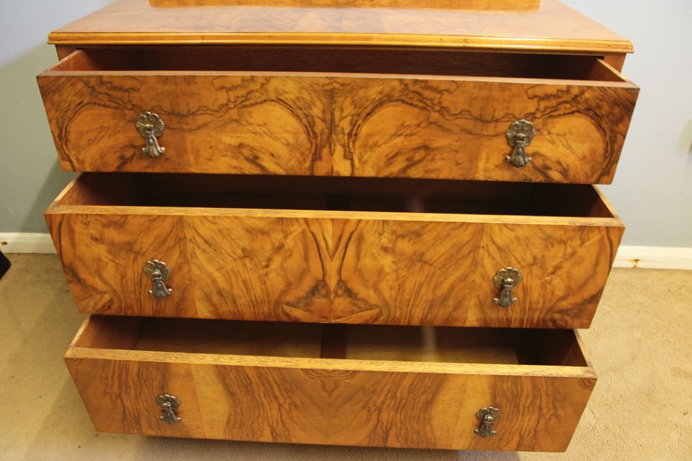 An antique figured walnut chest of drawers featuring three long drawers with decorative metal drop handles, supported on cabriole legs with a low gallery top. View XI