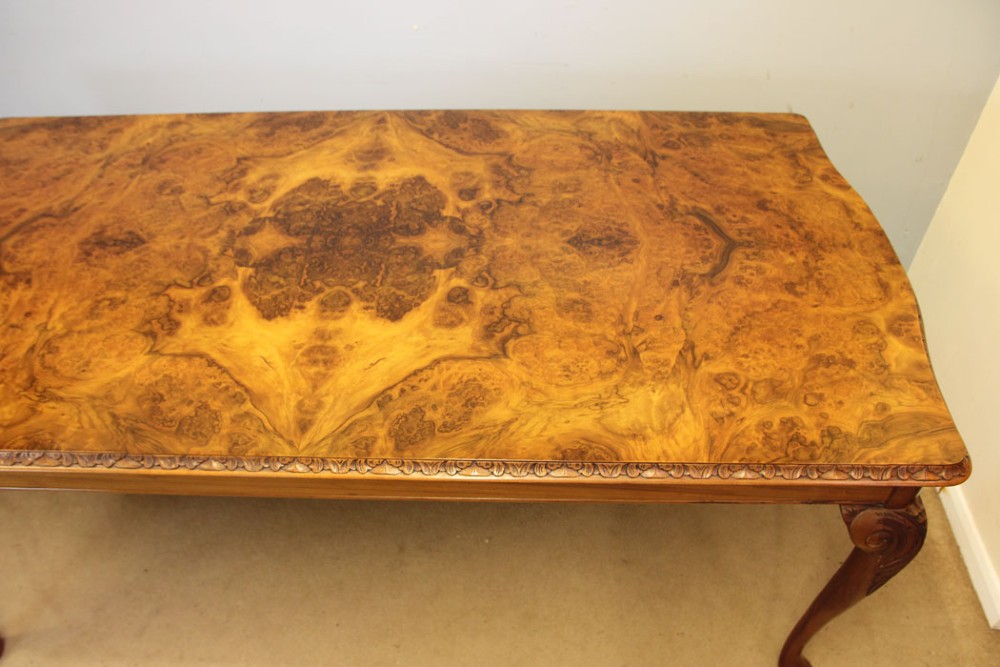 A rectangular burr walnut dining table featuring symmetrical book-matched veneer across the top, carved edge moulding, and cabriole legs. View II