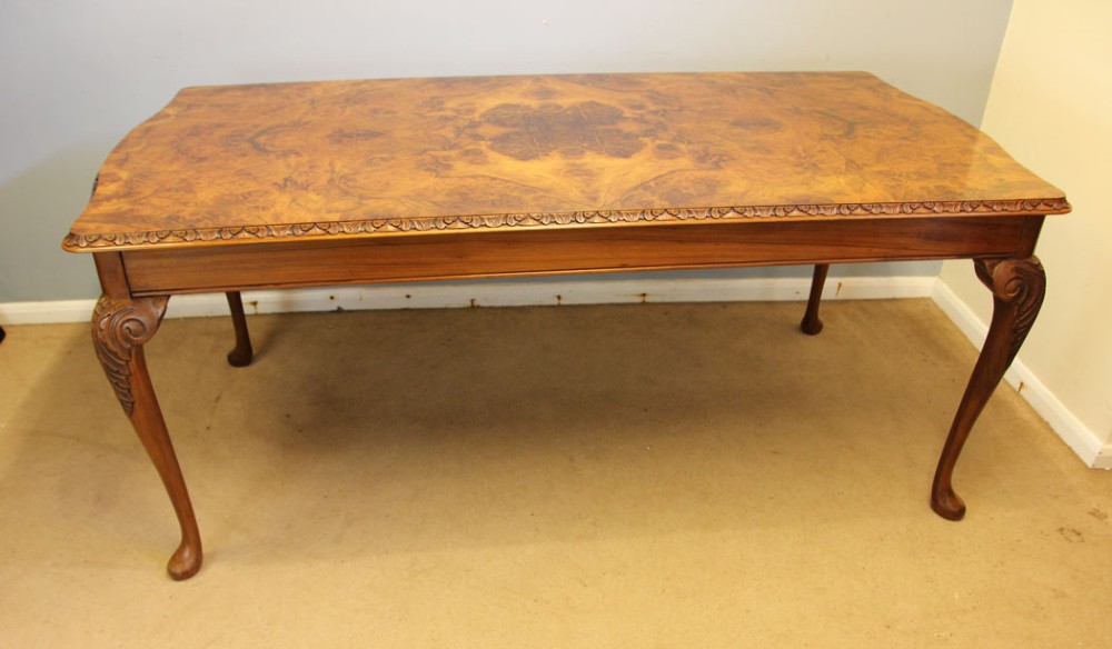 A rectangular burr walnut dining table featuring symmetrical book-matched veneer across the top, carved edge moulding, and cabriole legs. View VIII