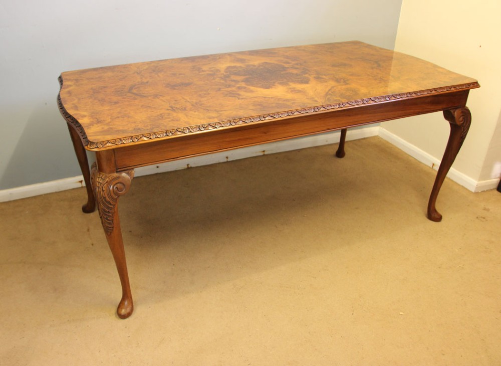 A rectangular burr walnut dining table featuring symmetrical book-matched veneer across the top, carved edge moulding, and cabriole legs. View IX