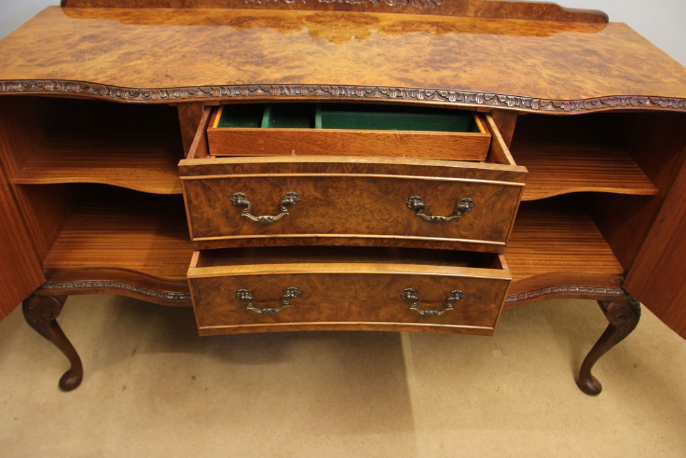 A burr walnut serpentine front sideboard featuring two central drawers flanked by side cupboards and raised on carved cabriole legs. View VII