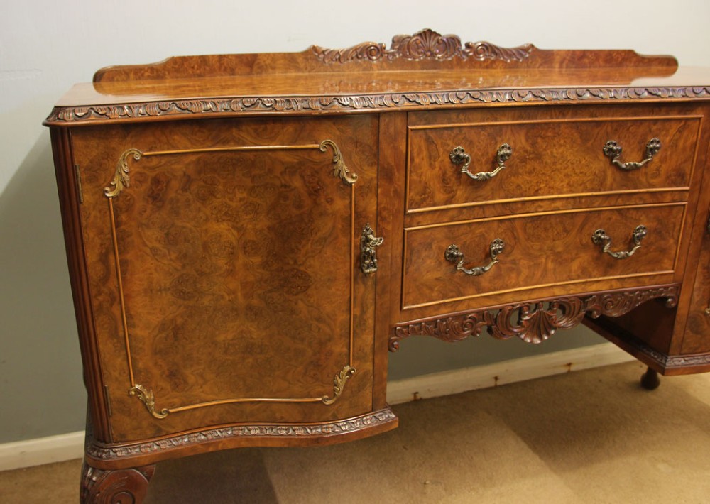 A burr walnut serpentine front sideboard featuring two central drawers flanked by side cupboards and raised on carved cabriole legs. View XII