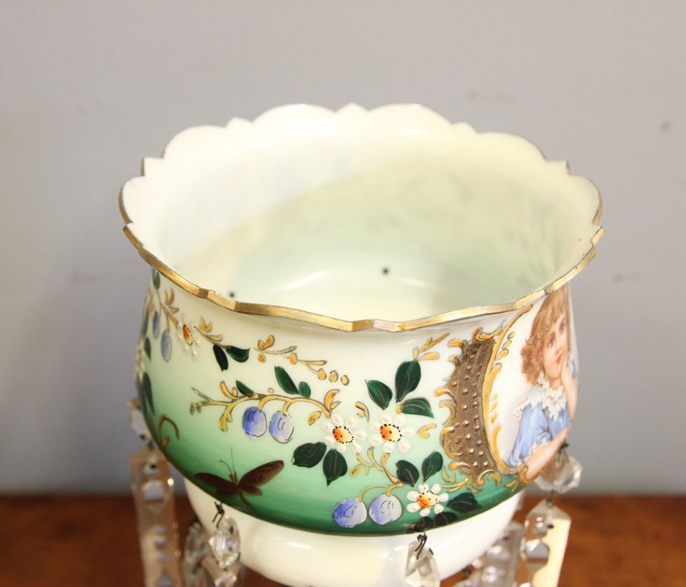 A Victorian opaque white and green glass mantle lustre featuring a hand-painted portrait vignette of a child, floral enamel accents, and suspended crystal prisms. View V