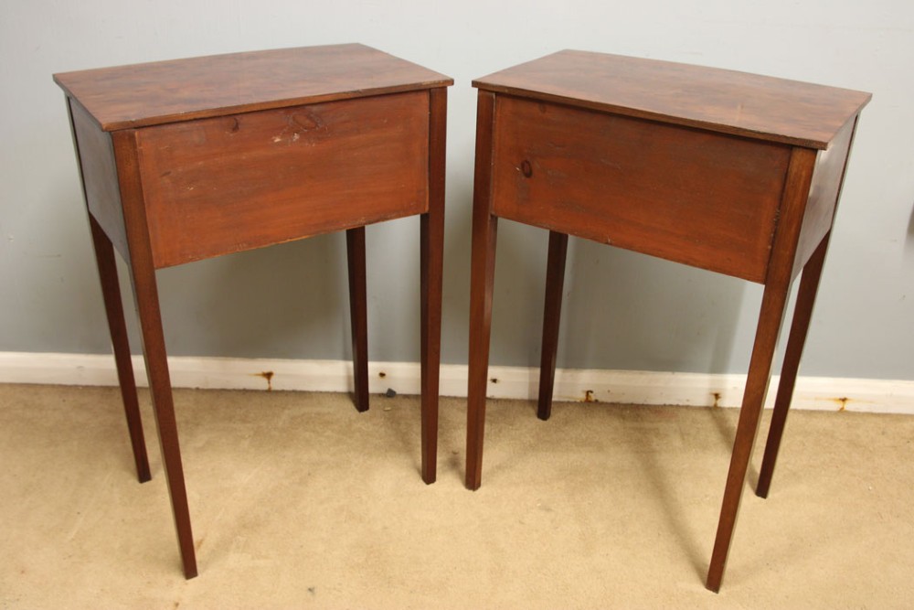 A pair of slim mahogany bedside tables, each featuring two drawers with brass knobs and tall square tapered legs. View X