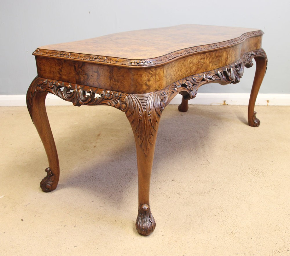 A low Queen Anne style burr walnut coffee table featuring carved cabriole legs, an ornate apron, and a serpentine book-matched top. View IV