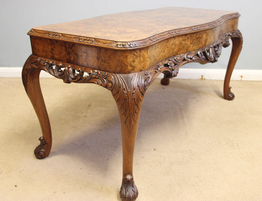 A low Queen Anne style burr walnut coffee table featuring carved cabriole legs, an ornate apron, and a serpentine book-matched top. View V