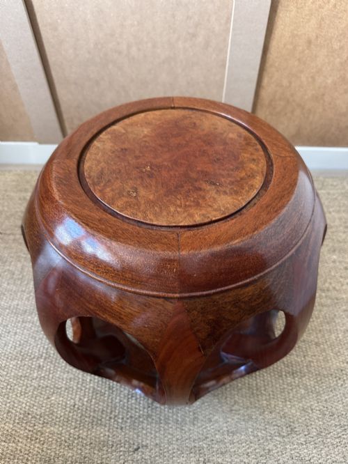 fig 2. A pair of carved dark hardwood barrel stools featuring rounded openwork frames and circular burr wood inset tops.