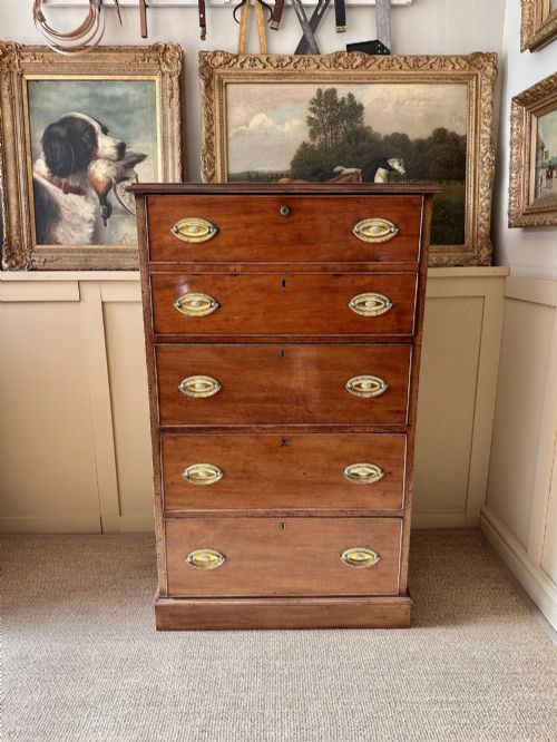 fig 1. An antique nineteenth-century mahogany Wellington secretaire chest with an open drop-front writing desk section revealing internal pigeonholes above three lower drawers.