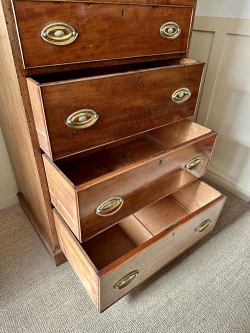 fig 3. An antique nineteenth-century mahogany Wellington secretaire chest with an open drop-front writing desk section revealing internal pigeonholes above three lower drawers.