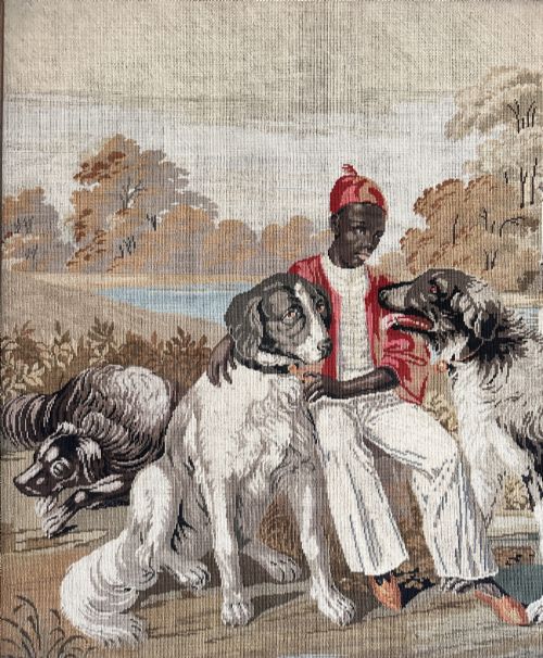 fig 1. A framed Victorian Berlin woolwork tapestry depicting a seated figure with two dogs in a parkland setting within a moulded gilt frame.