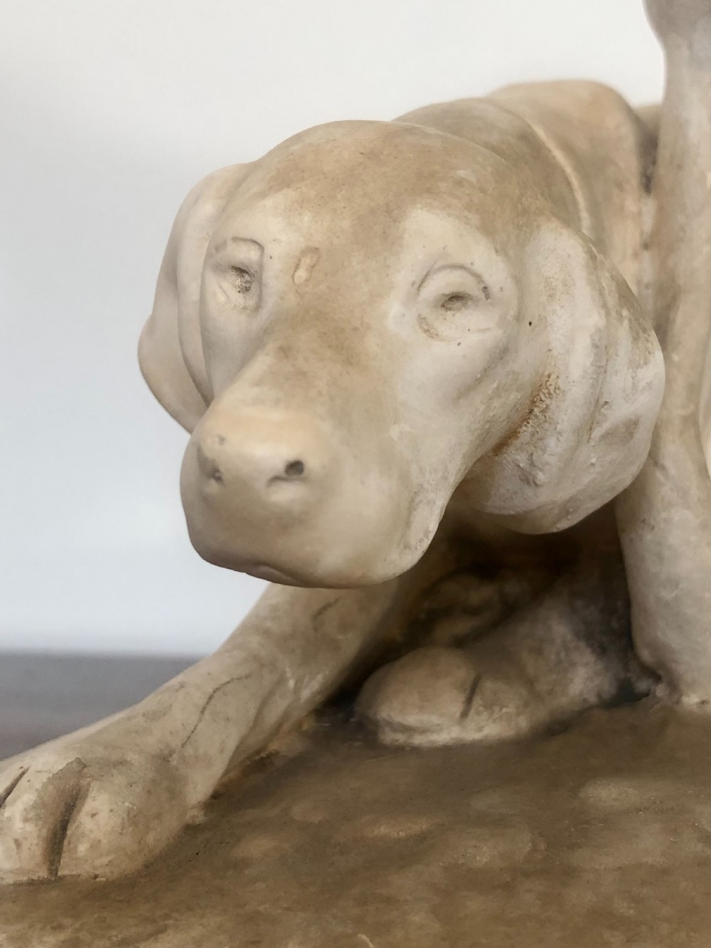 A 19th-century off-white Parian ware sculpture depicting two hunting hounds positioned on an integrated rectangular base. View VI