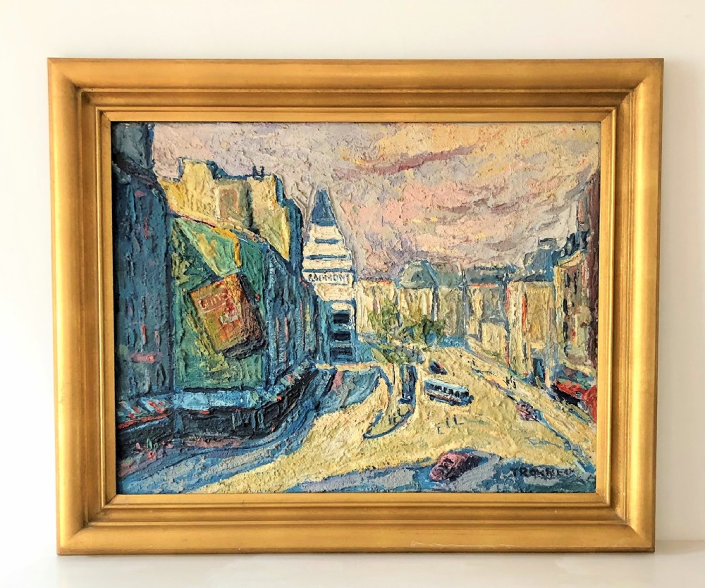 A framed mid-century oil painting depicting a Paris street scene rendered in heavy impasto strokes with yellow, blue, and pink tones inside a molded gold frame.