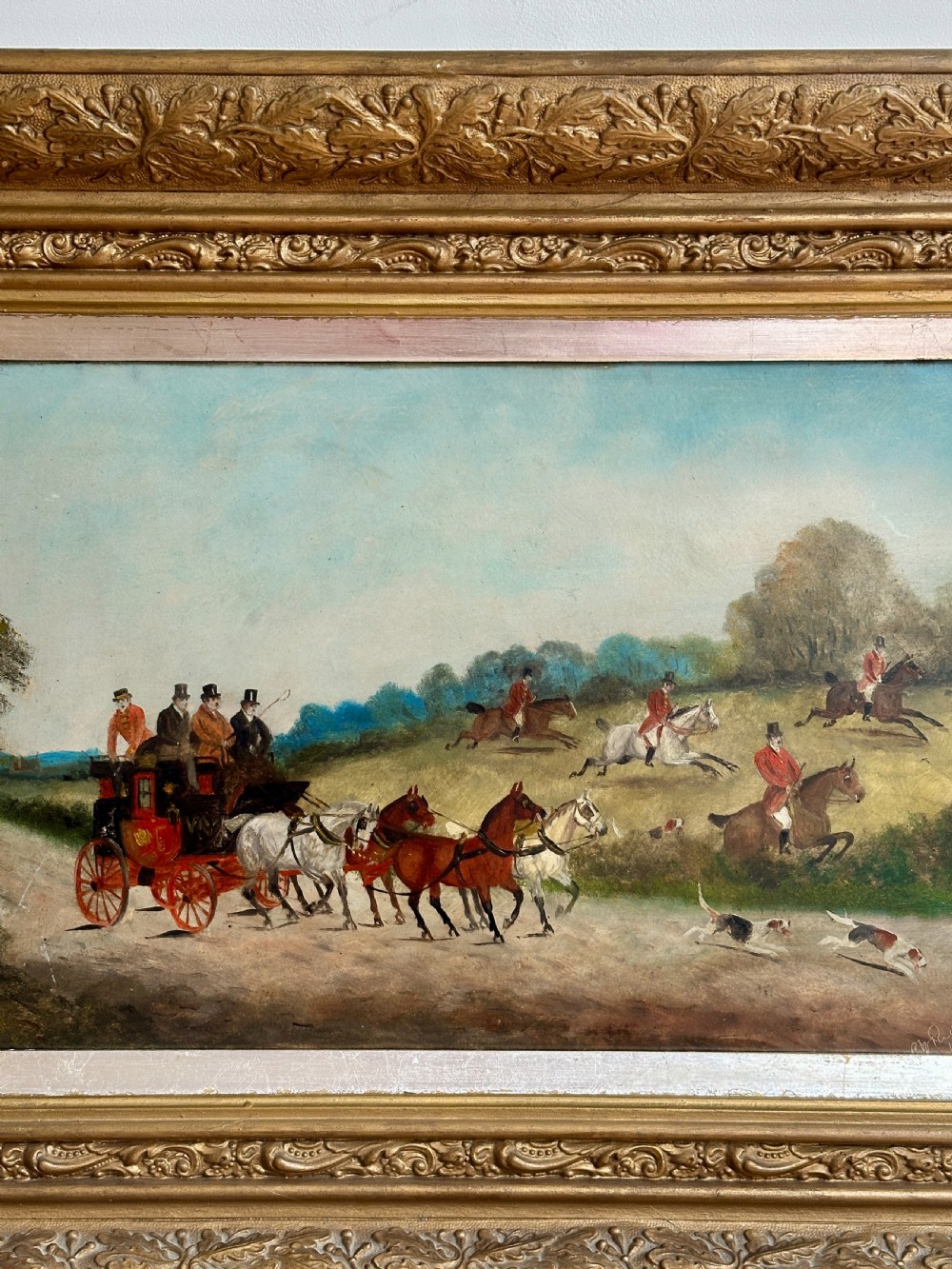 A pair of framed Edwardian oil paintings depicting horse-drawn coaches and fox hunting scenes within carved giltwood frames. View IV