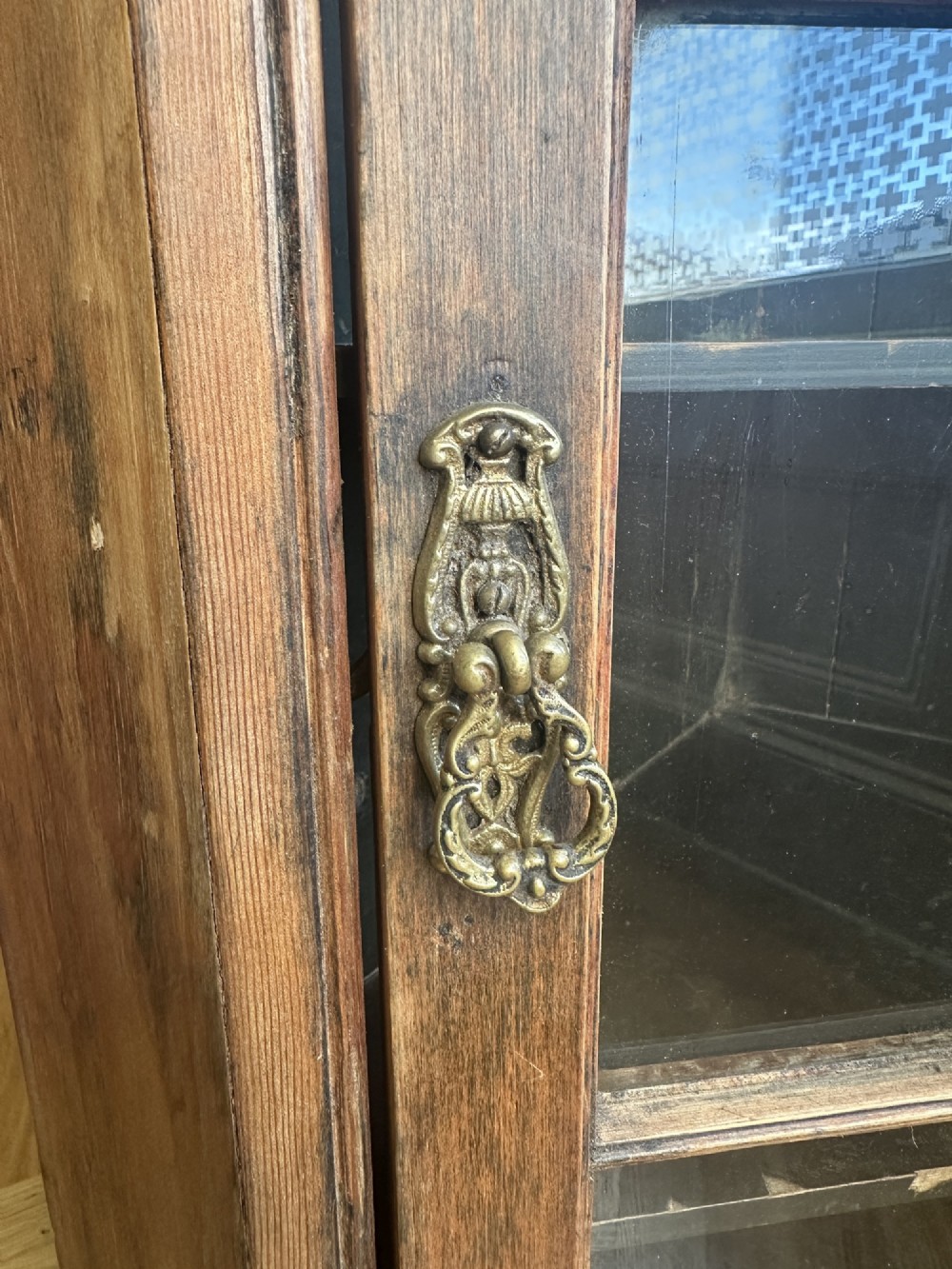 An antique stripped pine corner cabinet featuring a single glazed door with geometric astragal glazing bars and a dark painted interior. View IV