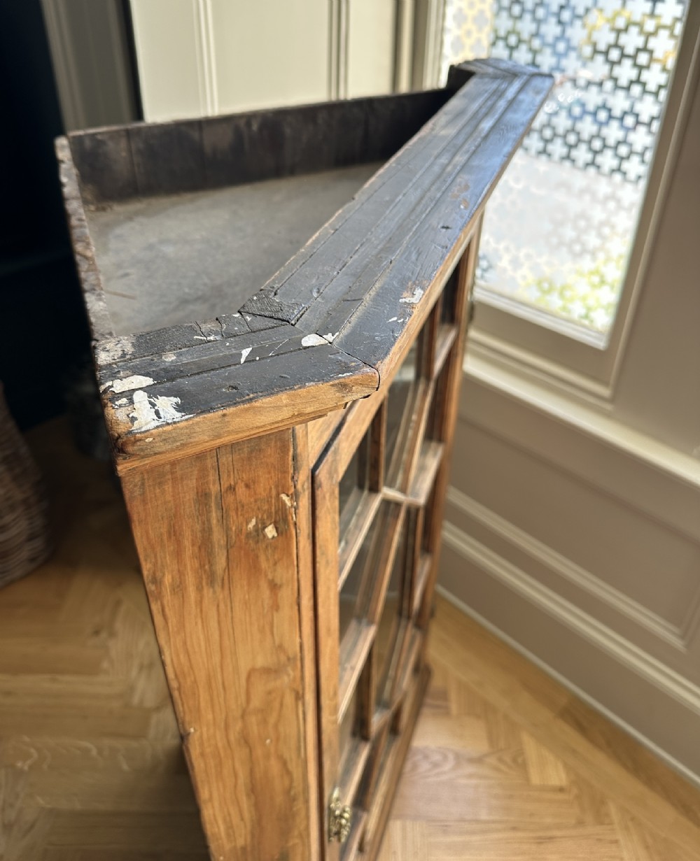 An antique stripped pine corner cabinet featuring a single glazed door with geometric astragal glazing bars and a dark painted interior. View V