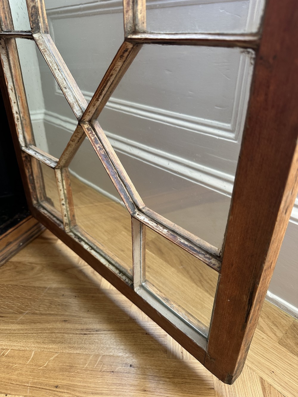 An antique stripped pine corner cabinet featuring a single glazed door with geometric astragal glazing bars and a dark painted interior. View VI