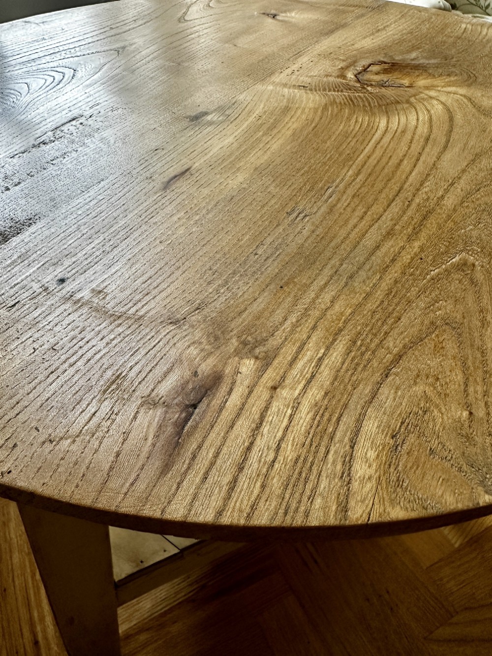 A rustic elm cricket table featuring a circular top, three splayed legs, and a lower triangular shelf. View III