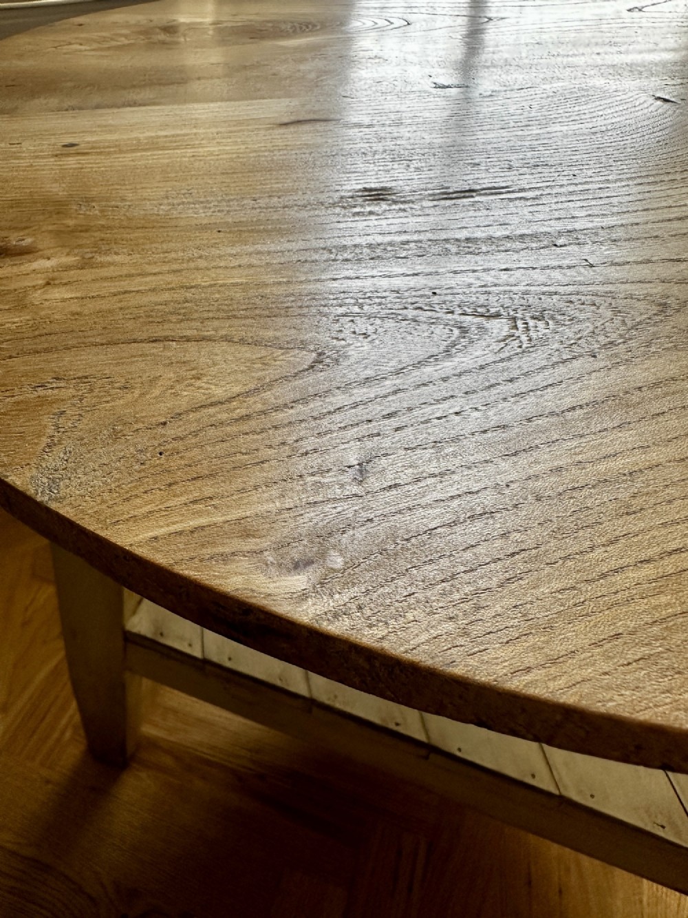 A rustic elm cricket table featuring a circular top, three splayed legs, and a lower triangular shelf. View IV