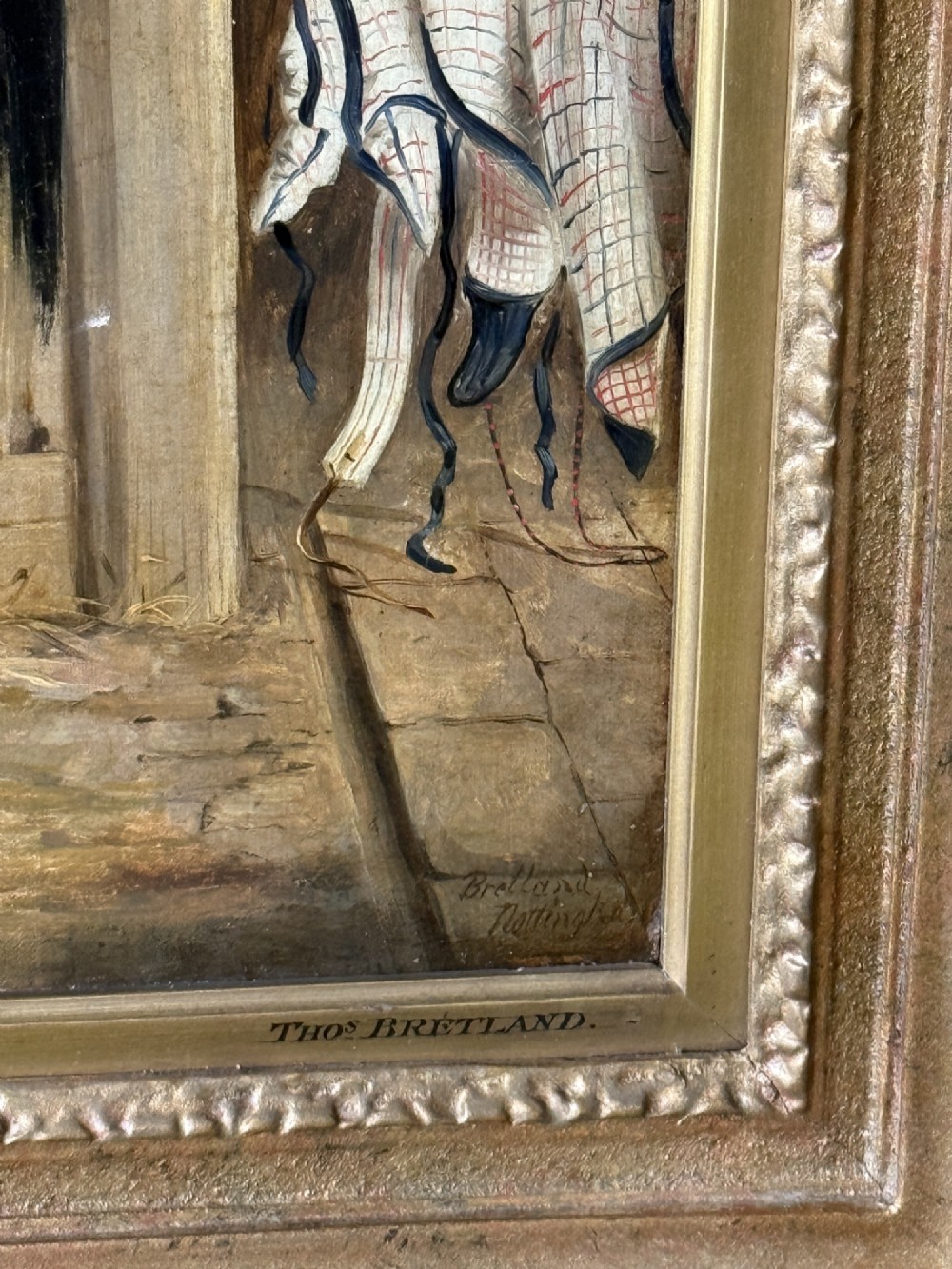 A Victorian oil painting depicting a brown racehorse standing in a straw-filled stable stall within a gilded frame. View VI